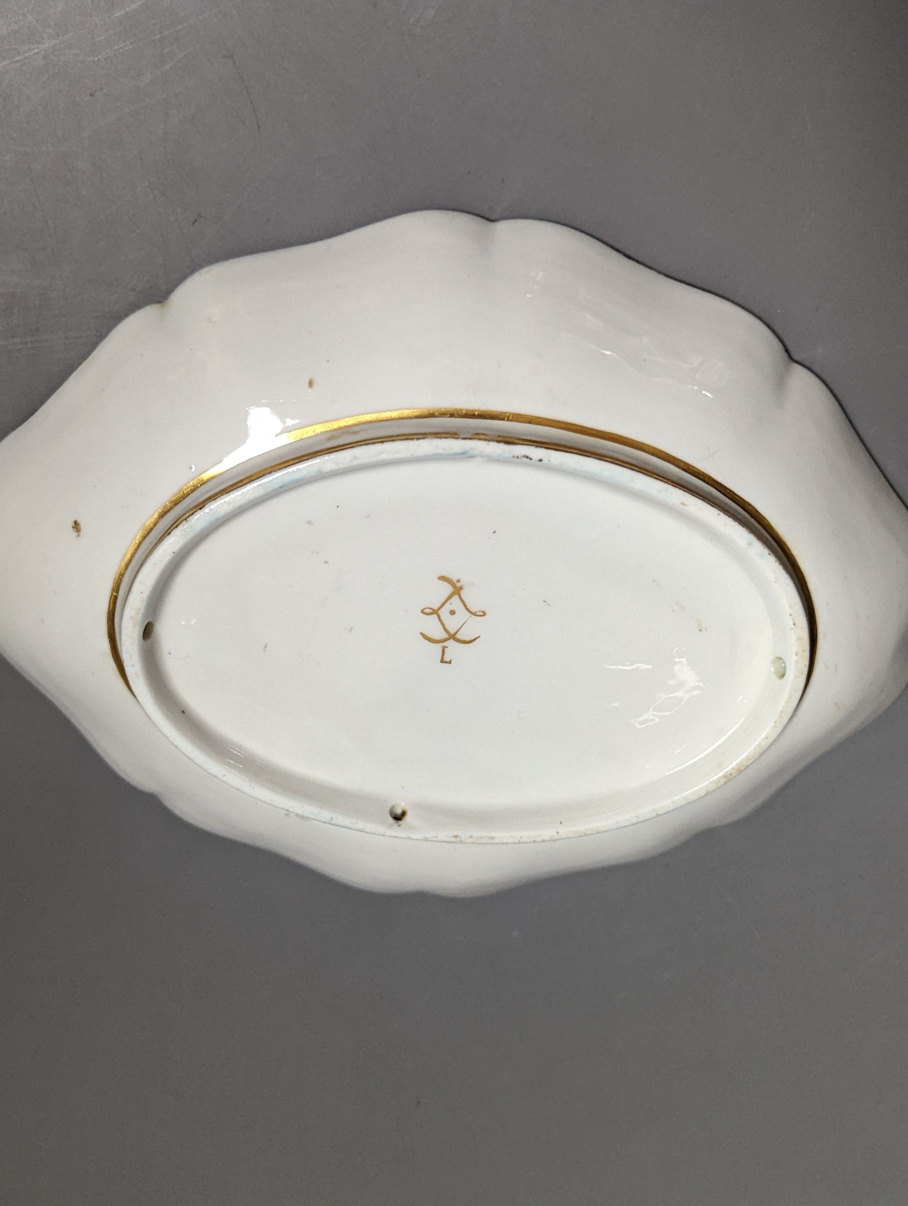 A 19th century Sevres oval shaped dish painted with a hunt scene, with three gentlemen, two dogs two horse and a lady watching surrounded by a turquoise and gilt ground, signed L Grise'e, 19cms wide
